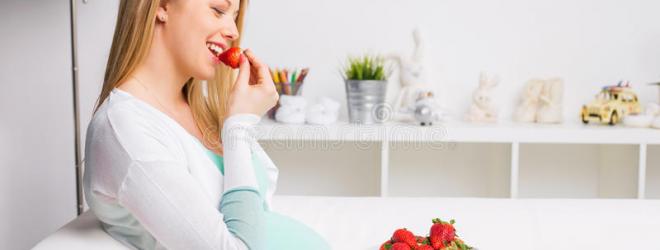 Pregnant woman eating strawberries