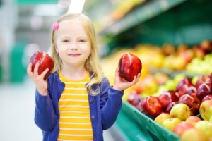Little,Girl,Choosing,Ripe,Apples,In,A,Food,Store,Or